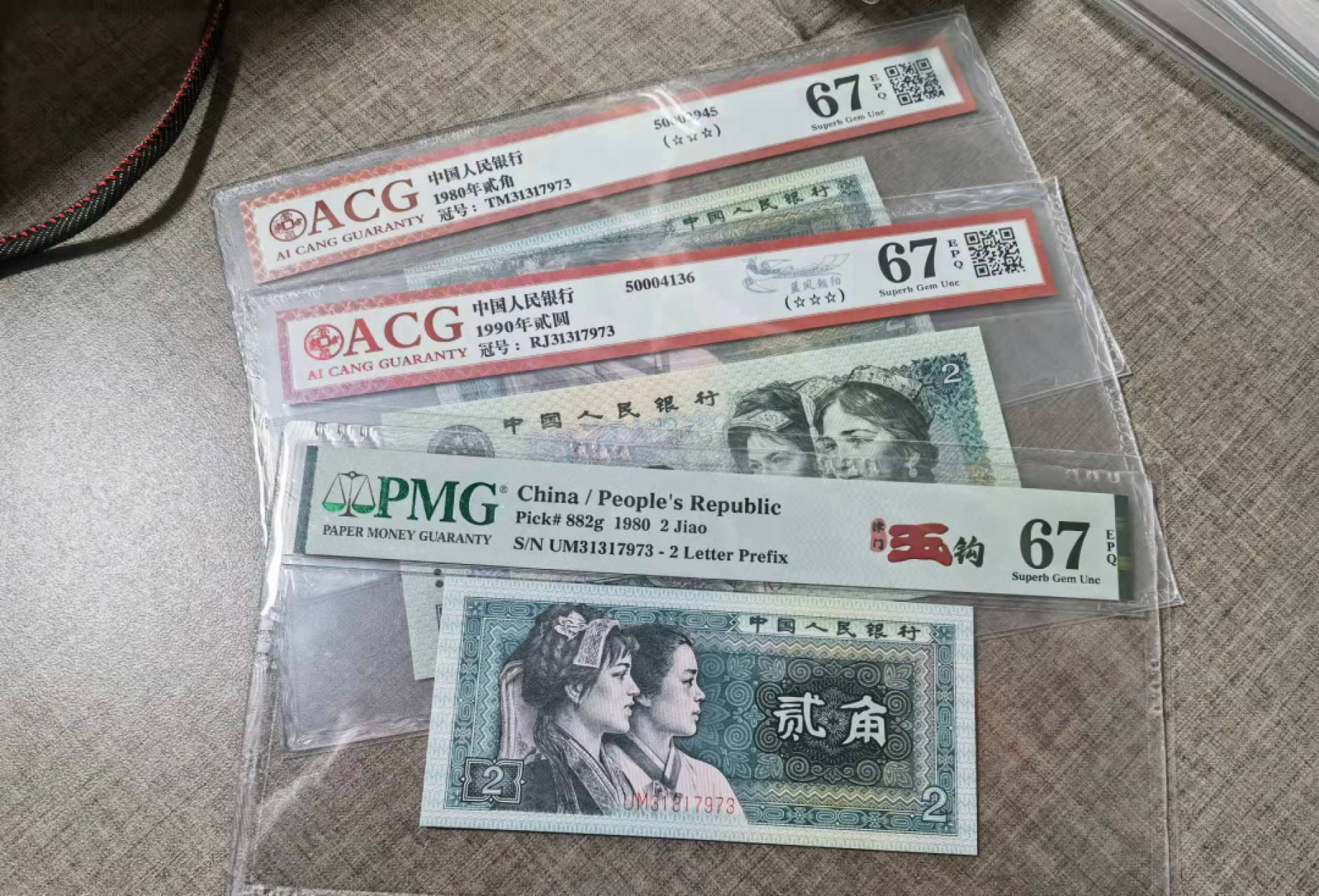俗钱雅币精品拍卖 四版8002和902稀品玉钩国PMG67爱藏蓝凤朝阳无4全奇数全同号全同分