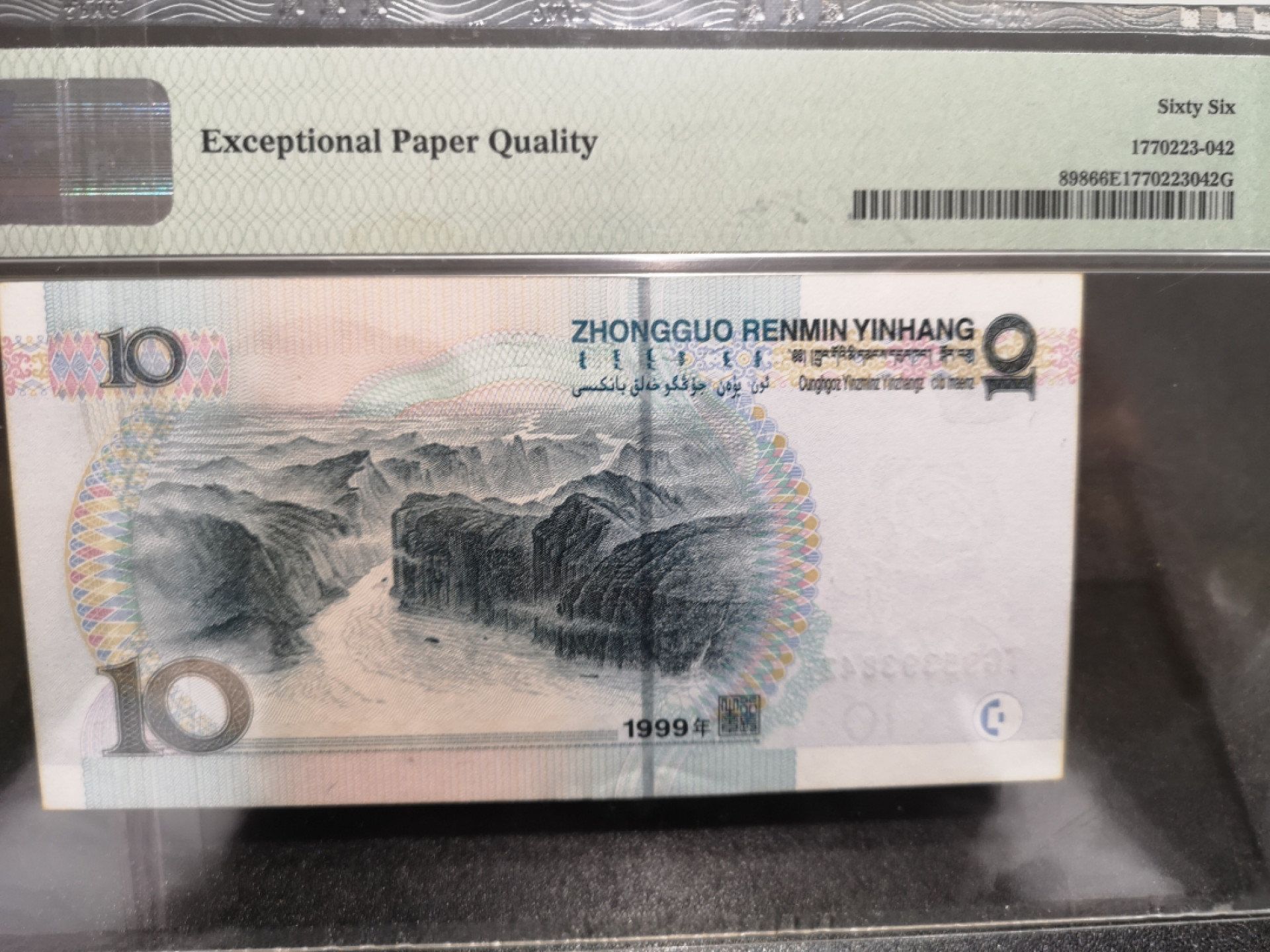 《外钞收藏家》第一百四十四期拍卖（本期85件） 1999年五版10元 PMG66 设计师签名标签 边上有不知原因的黄 参考图片