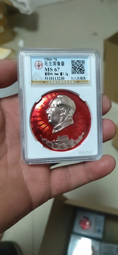 双11像章评级专场 - 公博评级毛主席像章—为人民服务，头像下方是三圣地浮雕，天安门是金色浮雕、井冈山和宝塔山是红色浮雕，天安门下方是七朵向日葵，背面有铭文：为人民服务，直径45.4毫米