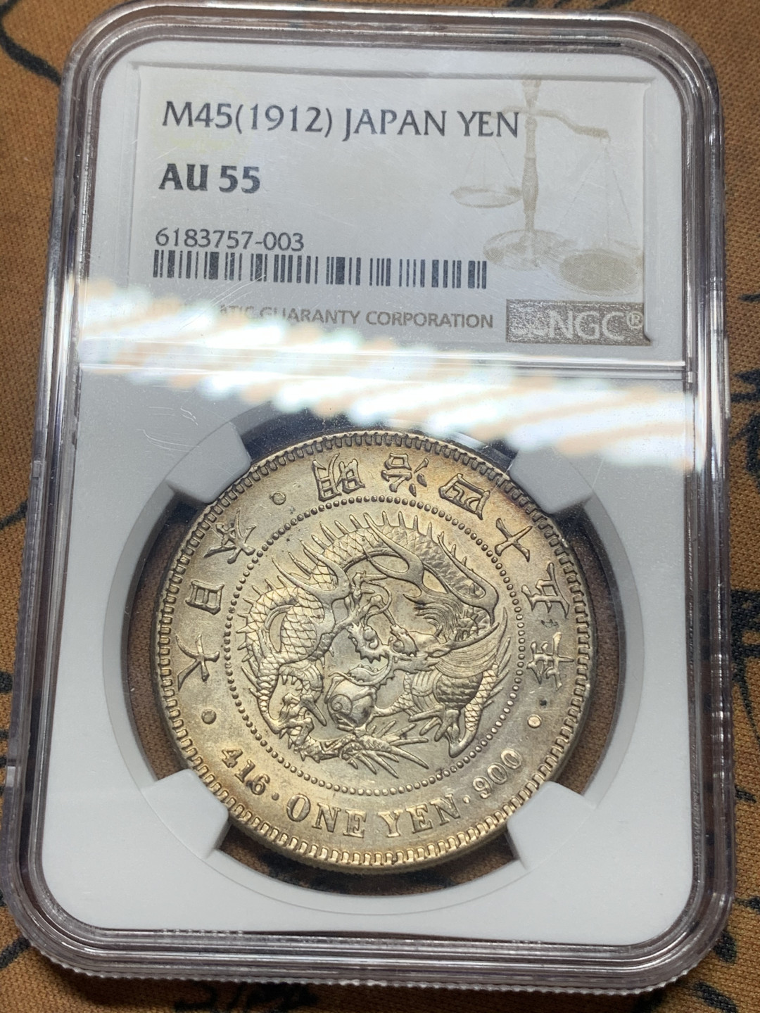 《竞宝斋》钱币微拍-第16场-本周日，周一2场连拍（全场顺丰包邮） NGC-AU55 日本龙洋明治四十五年，琥珀色包浆，淡金光，日本龙难得出彩的状态。龙面字面均完美，有冲击高分的能力