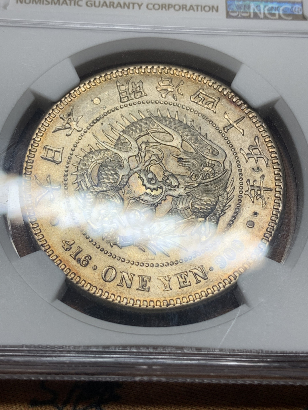 《竞宝斋》钱币微拍-第16场-本周日，周一2场连拍（全场顺丰包邮） NGC-AU55 日本龙洋明治四十五年，琥珀色包浆，淡金光，日本龙难得出彩的状态。龙面字面均完美，有冲击高分的能力