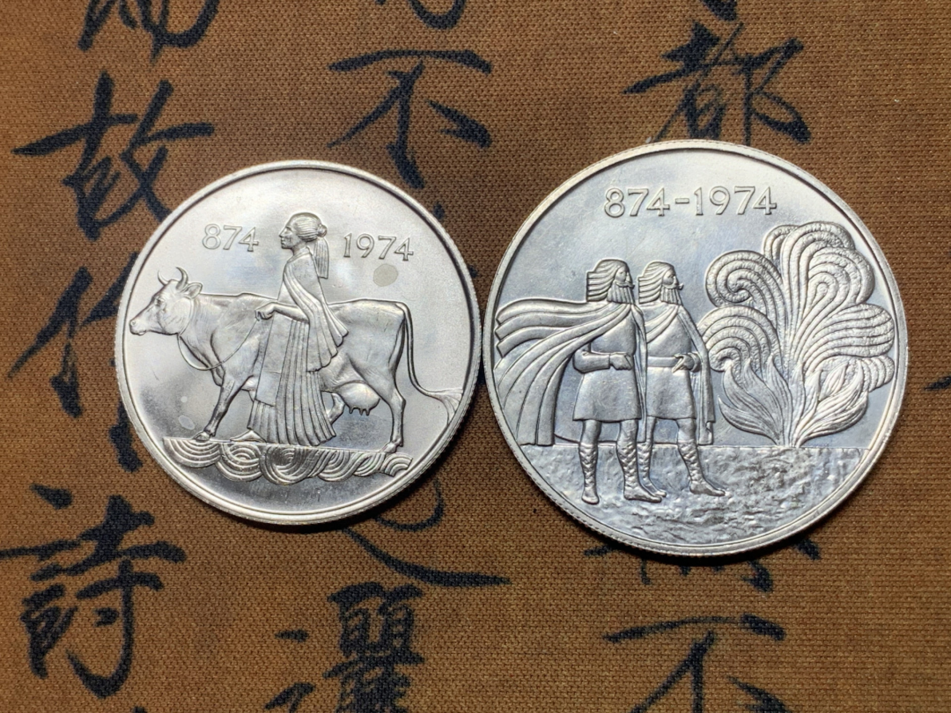 《竞宝斋》钱币微拍-第23场（全场顺丰包邮） 冰岛1974年定居1100周年纪念500克朗、1000克朗银币一对 835银，重量分别为5g、11g，直径分别为24mm、29.3mm，发行量7万5千枚。