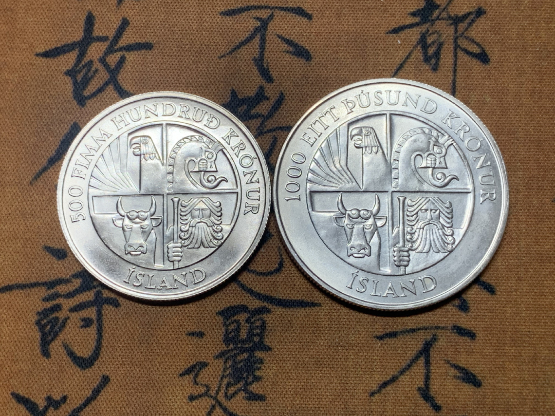 《竞宝斋》钱币微拍-第23场（全场顺丰包邮） 冰岛1974年定居1100周年纪念500克朗、1000克朗银币一对 835银，重量分别为5g、11g，直径分别为24mm、29.3mm，发行量7万5千枚。