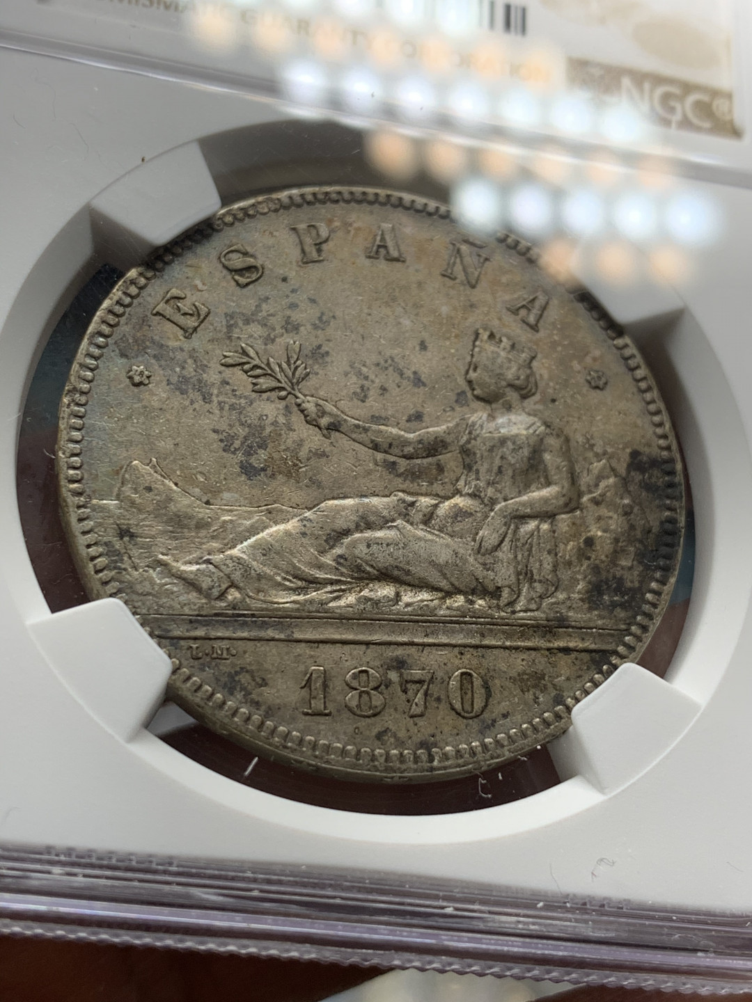 《竞宝斋》第28场-本周日，周一2场连拍（全场顺丰包邮） NGC 评级 深五彩 西班牙 1870年 5比塞塔 坐人拿花 大银币 细节很好，高点清晰