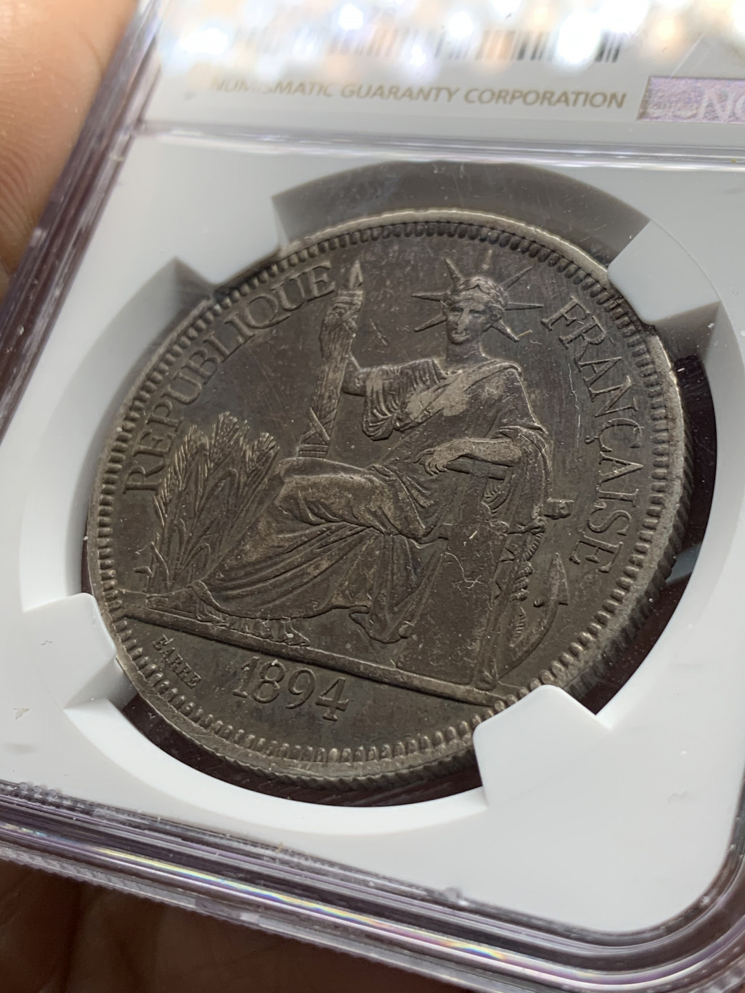 《竞宝斋》第31场（年内尾拍）-周日，周一，周二3场连拍（全场顺丰包邮） NGC 评级 深黑发财包浆 法属印支 1894年加重坐人 银币 鼻尖磨损 整体保存的很好