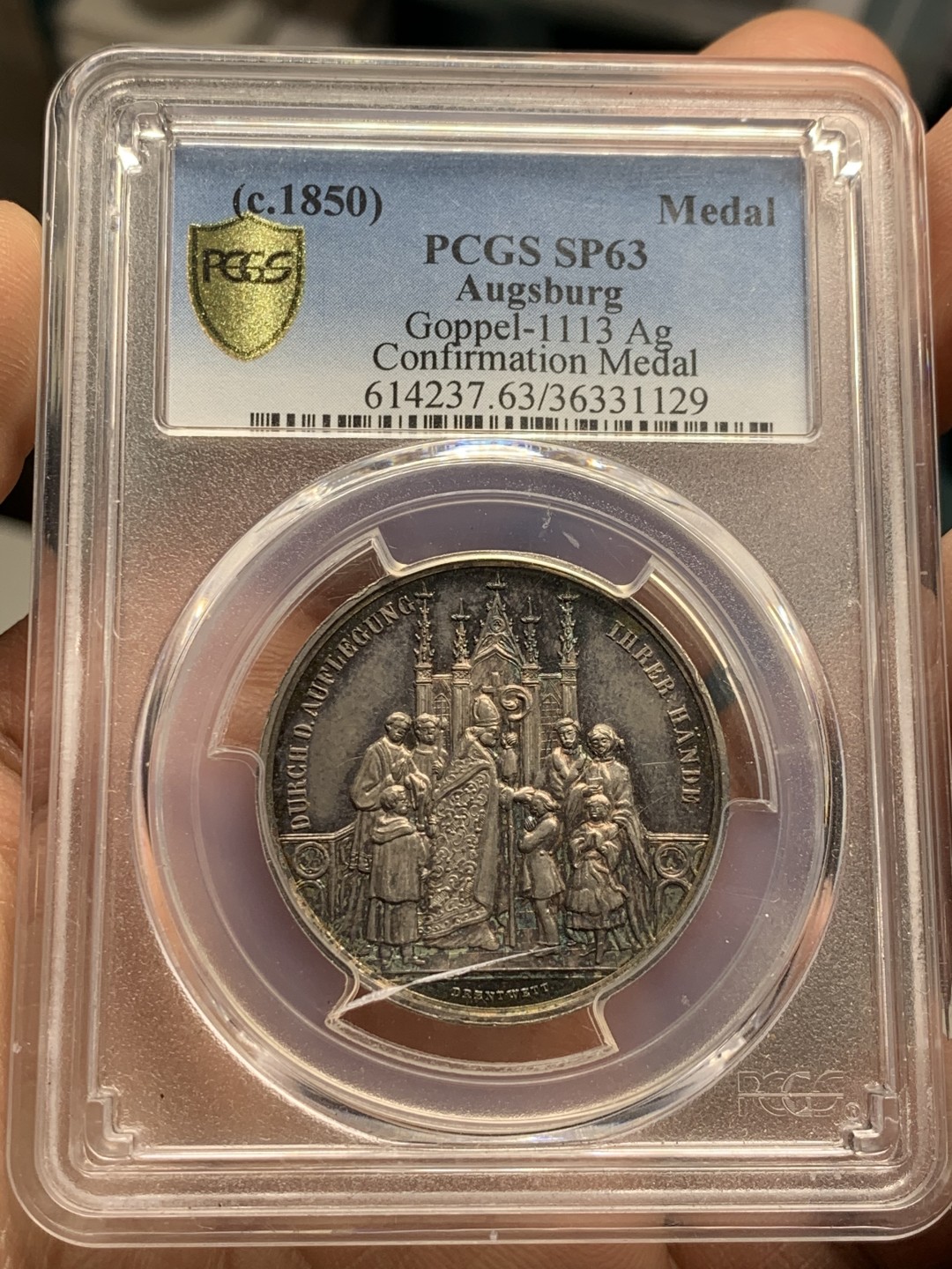 《竞宝斋》第36场-本周日 （全场顺丰包邮） pcgs-sp63 1850年德国奥格斯堡天主教洗礼银样章 双面紫罗兰镜面五彩 雕刻精细 冠军分 实物观感极佳 奥格斯堡建于公元前15年罗马皇帝奥古斯都时代 著名的文艺复兴之都 莫扎特的故居 盒子正面有小裂
