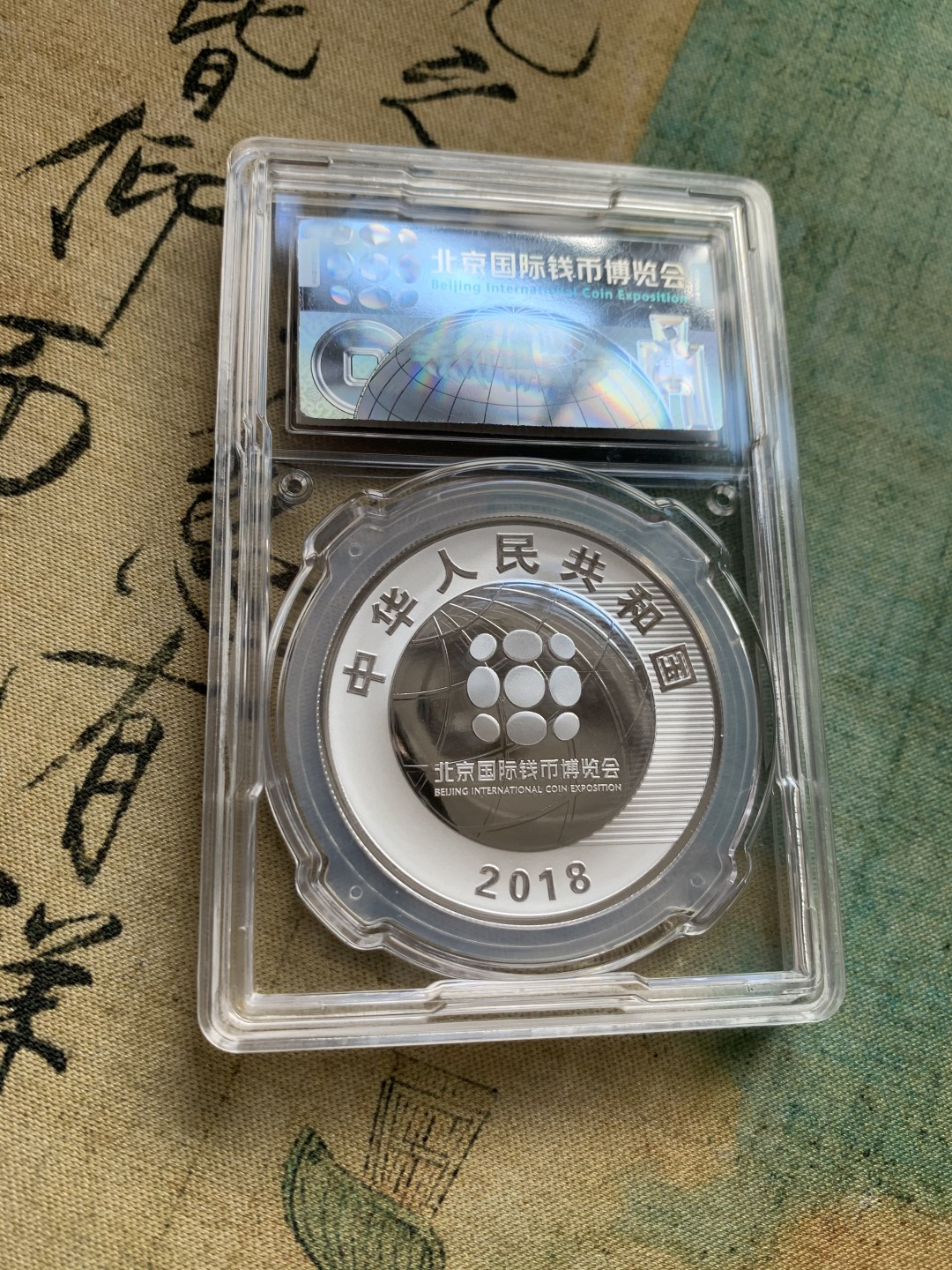 《竞宝斋》第38场-本周一 （全场顺丰包邮） (纪念银币+护照，全套)2018年 北京国际币展现场纪念册 纪念银币1枚 护照一本 邮戳齐 带荧光戳 封面为一枚生肖银章 