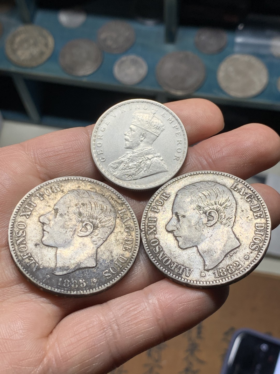 《竞宝斋》第38场-本周一 （全场顺丰包邮） 西班牙双柱5比塞塔两枚+印度卢比一枚 双柱1882（82）MSM+1885（87）MSM 传世老包浆 1885月牙彩 味道一流；卢比1916B MS品相 转光明显 深打细节优秀