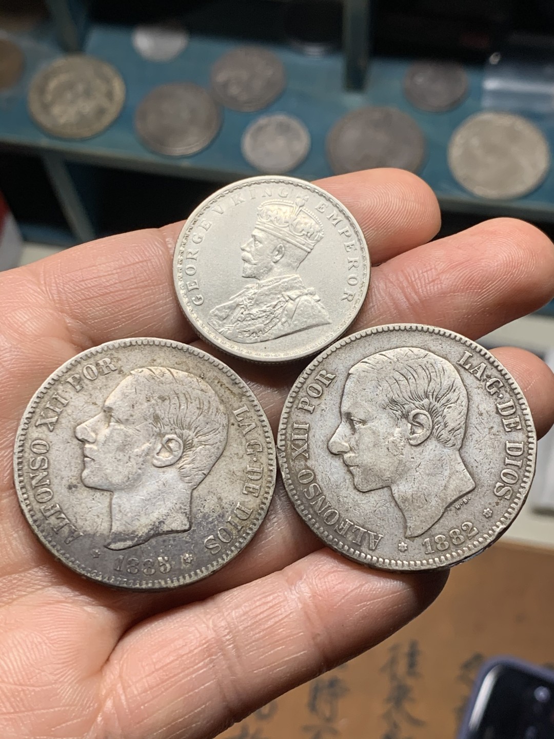 《竞宝斋》第38场-本周一 （全场顺丰包邮） 西班牙双柱5比塞塔两枚+印度卢比一枚 双柱1882（82）MSM+1885（87）MSM 传世老包浆 1885月牙彩 味道一流；卢比1916B MS品相 转光明显 深打细节优秀