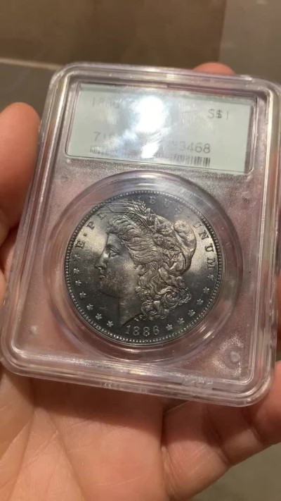 《竞宝斋》第38场-本周一 （全场顺丰包邮） PCGS-MS63 美国 1886年 摩根币 7位数编号老绿盒 黑色包浆 盒上有道划痕