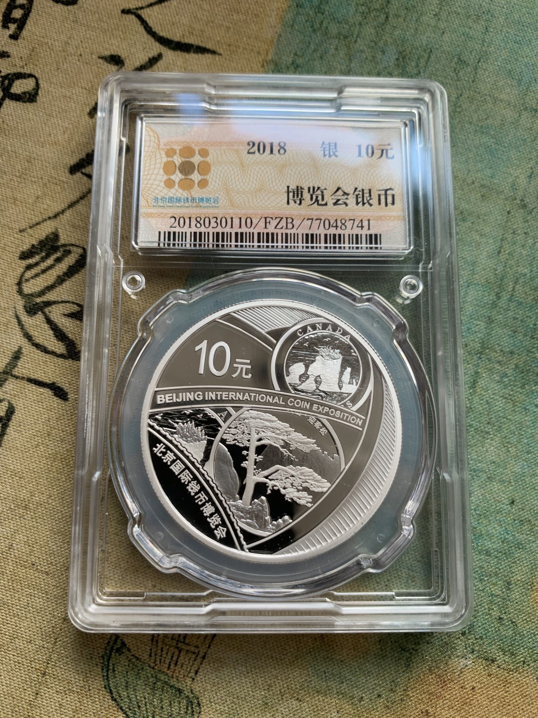 《竞宝斋》第38场-本周一 （全场顺丰包邮） (纪念银币+护照，全套)2018年 北京国际币展现场纪念册 纪念银币1枚 护照一本 邮戳齐 带荧光戳 封面为一枚生肖银章 