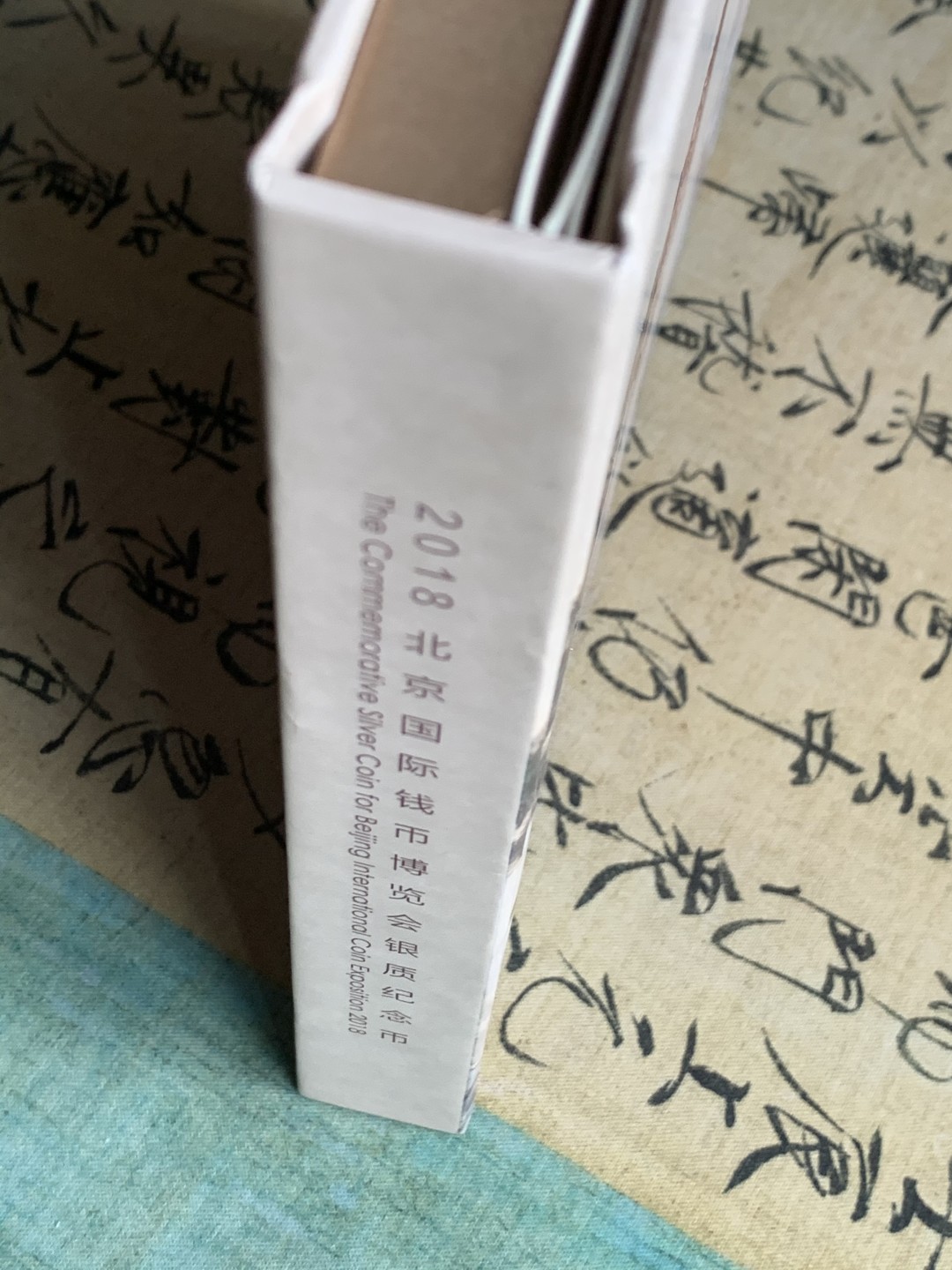 《竞宝斋》第38场-本周一 （全场顺丰包邮） (纪念银币+护照，全套)2018年 北京国际币展现场纪念册 纪念银币1枚 护照一本 邮戳齐 带荧光戳 封面为一枚生肖银章 