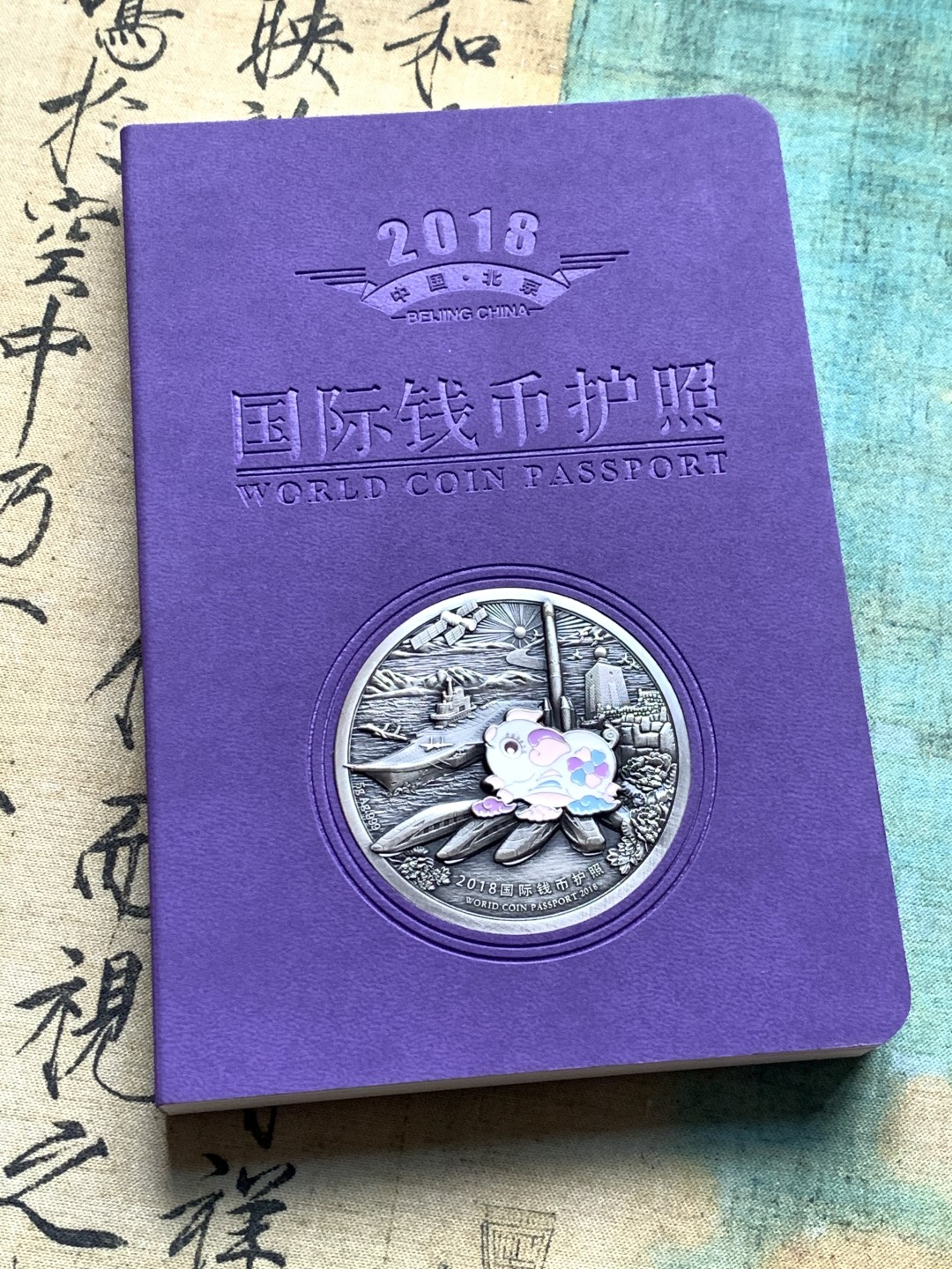 《竞宝斋》第38场-本周一 （全场顺丰包邮） (纪念银币+护照，全套)2018年 北京国际币展现场纪念册 纪念银币1枚 护照一本 邮戳齐 带荧光戳 封面为一枚生肖银章 