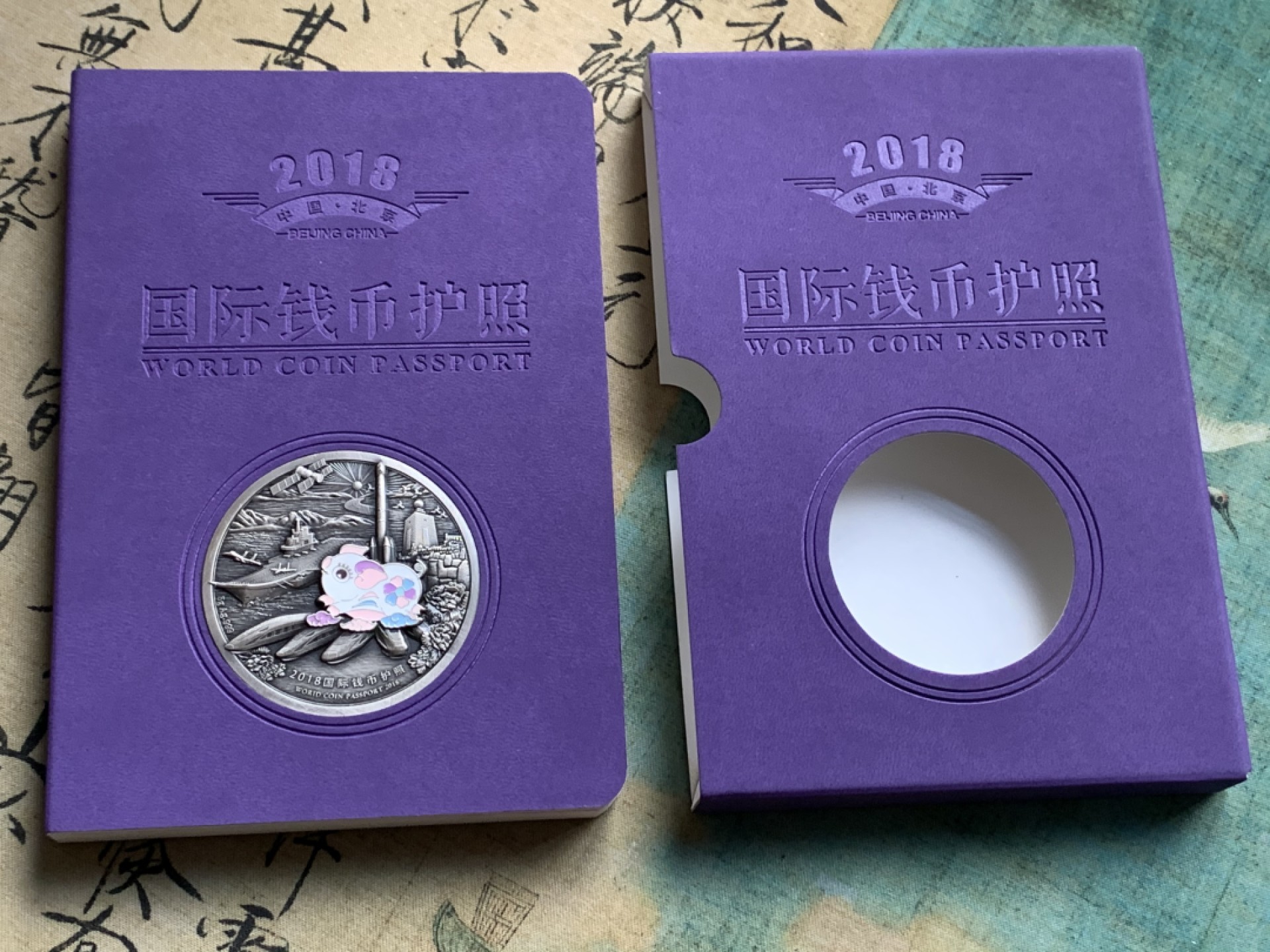 《竞宝斋》第38场-本周一 （全场顺丰包邮） (纪念银币+护照，全套)2018年 北京国际币展现场纪念册 纪念银币1枚 护照一本 邮戳齐 带荧光戳 封面为一枚生肖银章 