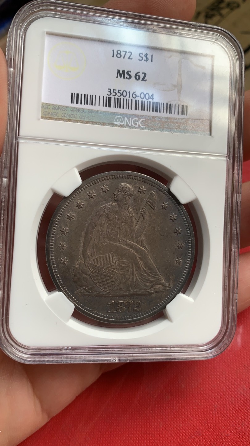 《竞宝斋》第43场-本周日，周一2场连拍（全场顺丰包邮） NGC-MS62 稀少五彩炭黑包浆 美国 1872年 拿旗坐人 1美元 大银币 难得一遇之状态