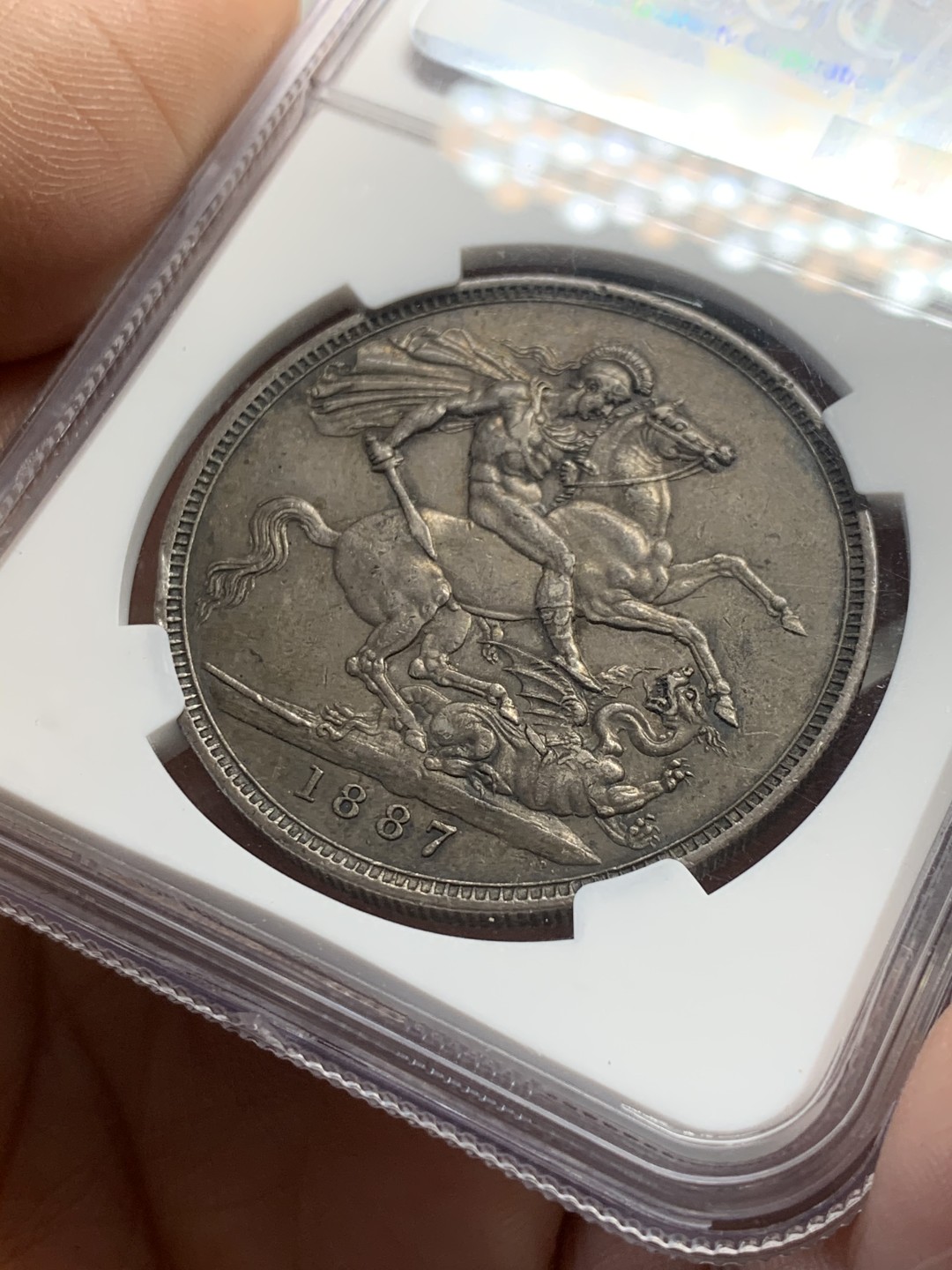 《竞宝斋》第44场-本周日，周一2场连拍（全场顺丰包邮） NGC AU53 黑彩深包浆 英国 1887年 维多利亚 高冠 马剑克朗银币 包浆币给分实在不容易