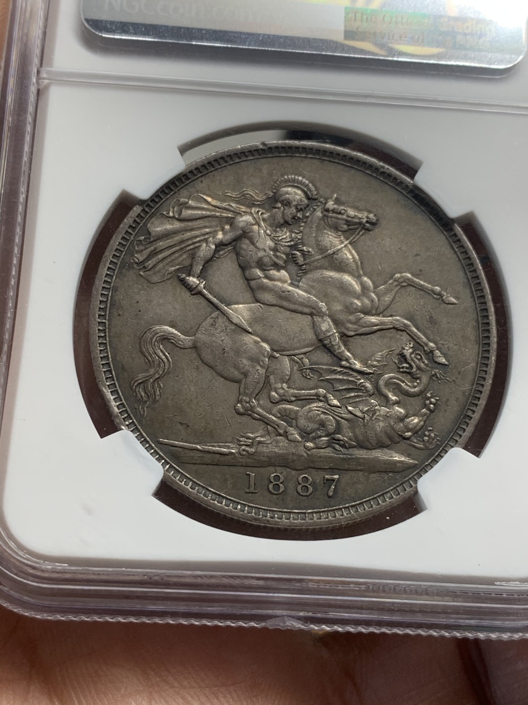 《竞宝斋》第44场-本周日，周一2场连拍（全场顺丰包邮） NGC AU53 黑彩深包浆 英国 1887年 维多利亚 高冠 马剑克朗银币 包浆币给分实在不容易