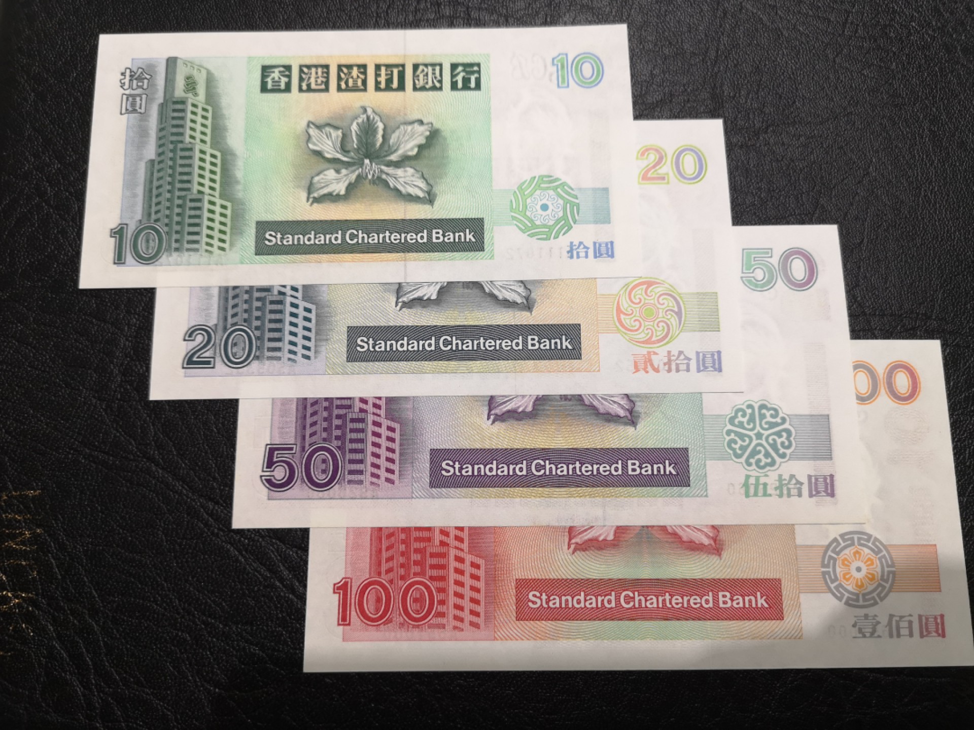 《外钞收藏家》第一百七十三期拍卖 1993年香港渣打银行10、100小套4张 全部A冠 100轻微潮癍 50潮癍比较多 其他很好