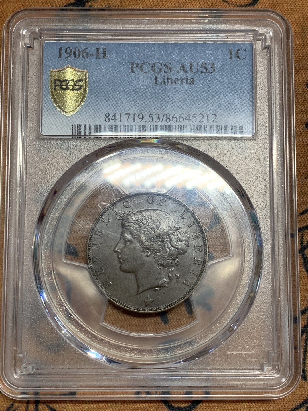 《竞宝斋》第46场-本周日，周一2场连拍（全场顺丰包邮） PCGS AU53 利比里亚 1906年 1分铜币H版 PCGS唯一冠军分 英国伯明翰喜墩造币厂 背面海平面 太阳 飞鸟 椰树 帆船的设计让人叹为观止