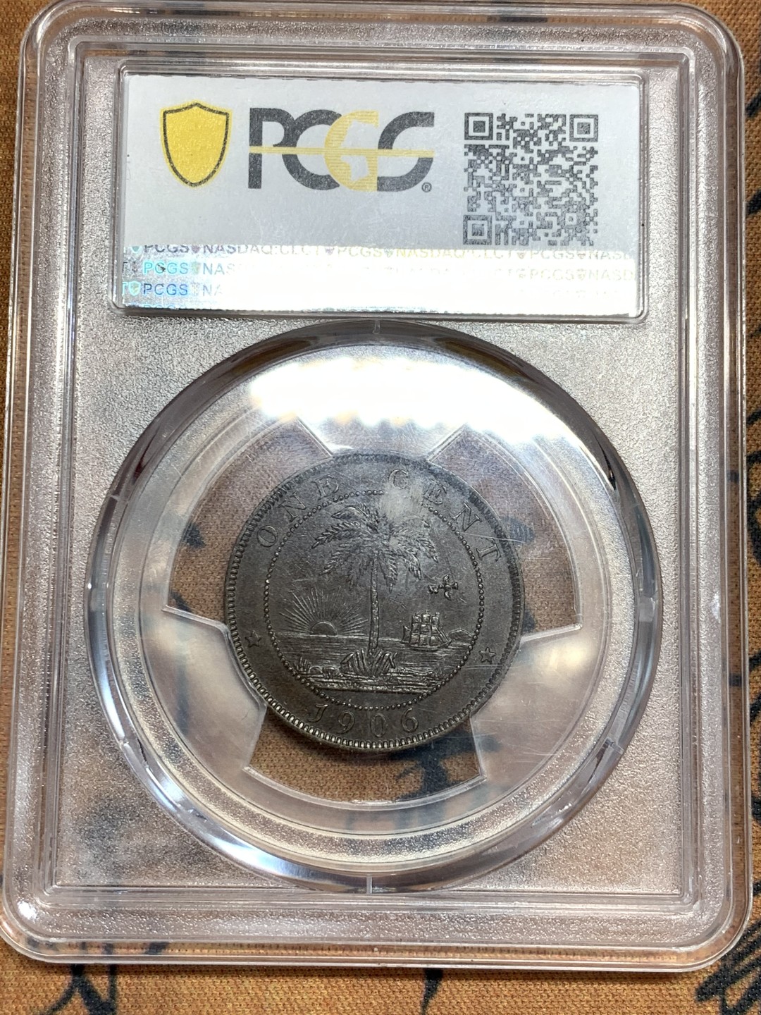 《竞宝斋》第46场-本周日，周一2场连拍（全场顺丰包邮） PCGS AU53 利比里亚 1906年 1分铜币H版 PCGS唯一冠军分 英国伯明翰喜墩造币厂 背面海平面 太阳 飞鸟 椰树 帆船的设计让人叹为观止