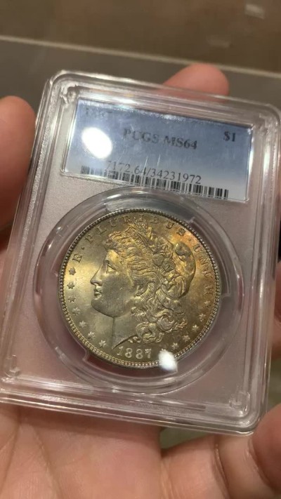 《竞宝斋》第48场-本周日，周一2场连拍（全场不限金额包邮） PCGS-MS64 美国 1887年 摩根 银币，完全未流通，面应该是卷首金彩，背带环彩，奶油光。