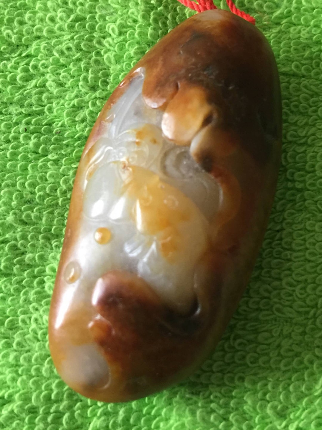 和田玉红皮籽料雕白玉挂件：连年有余。
