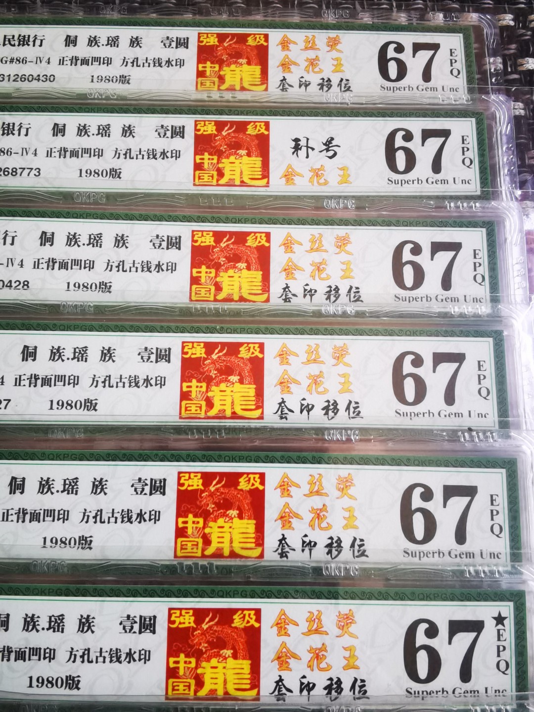  千家老金精品！中国龙里的稀罕物，金丝荧！Fq3126是公认的传统强流水，也是当年PMG开标的重要流水之一！在钱坤开标时意外在个别刀货中发现奇异的金丝荧，在每一张钱币的右侧中部都有一根金色的荧光线，整刀相同！众所周知，人民币的荧光丝是从961才开始出现，为什么出现在801中国龙不得而知！捡漏来千家，旨在打造全世界最为纯净的拍场！  千家老金精品！中国龙里的稀罕物，金丝荧！金花王，套印移位花头发（人像整体右移位形成独特的花头发），强级中国龙！Fq31260441，钱坤评级67分！公认的传统强流水，也是当年PMG开标的重要流水之一！在钱坤开标时意外在个别刀货中发现奇异的金丝荧，在每一张钱币的右侧中部都有一根金色的荧光线，整刀相同！众所周知，人民币的荧光丝是从961才开始出现，为什么出现在801中国龙不得而知！