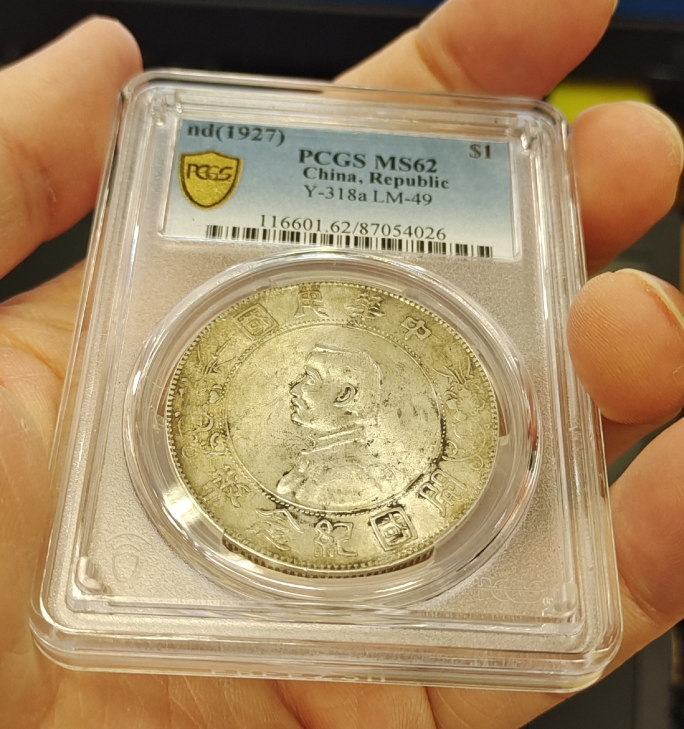 【华誉王者】1998期拍卖 浓黄金彩转轮光老包浆孙像开国纪念币PCGS62分，正常办公室光灯下手机照片直出无后期美化加工，正反面都是深色浓厚黄金彩，前后转轮光，带老包浆，编码87054026。