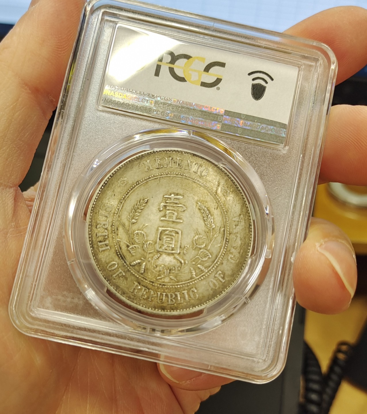 【华誉王者】1998期拍卖 浓黄金彩转轮光老包浆孙像开国纪念币PCGS62分，正常办公室光灯下手机照片直出无后期美化加工，正反面都是深色浓厚黄金彩，前后转轮光，带老包浆，编码87054026。