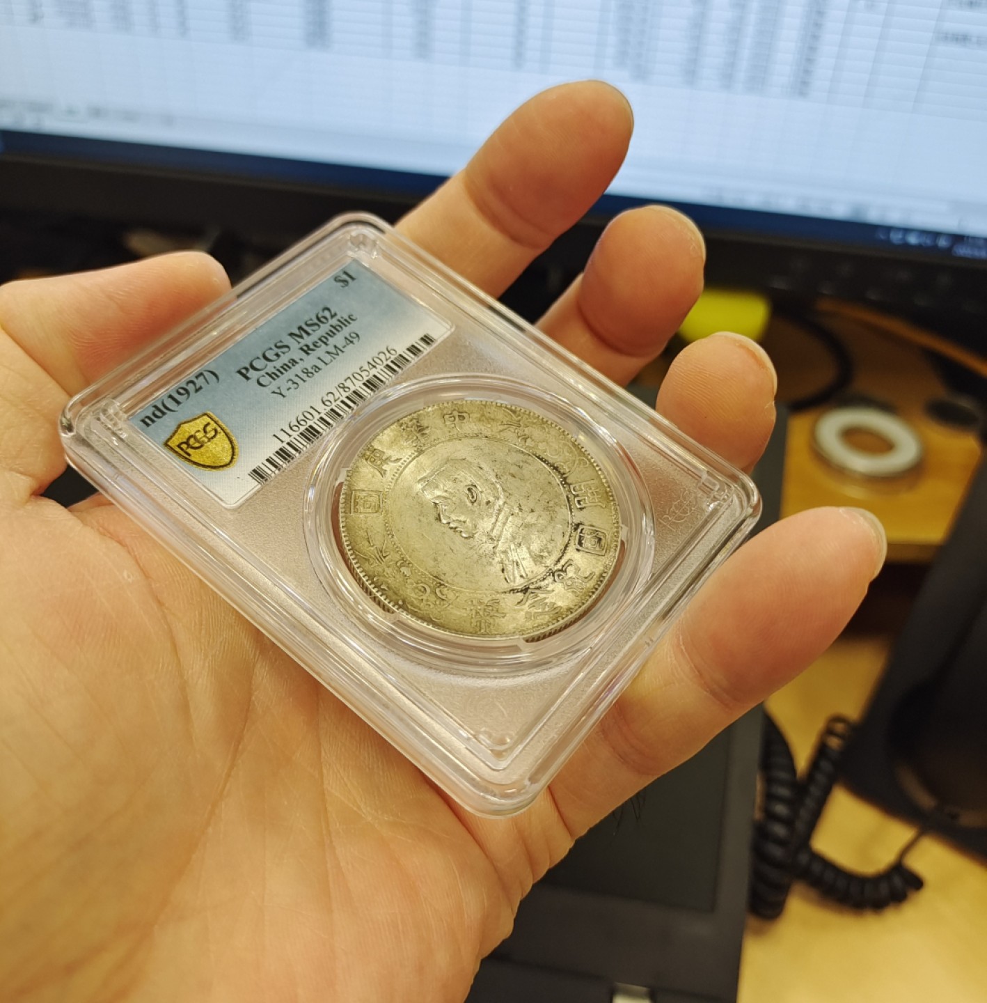 【华誉王者】1998期拍卖 浓黄金彩转轮光老包浆孙像开国纪念币PCGS62分，正常办公室光灯下手机照片直出无后期美化加工，正反面都是深色浓厚黄金彩，前后转轮光，带老包浆，编码87054026。