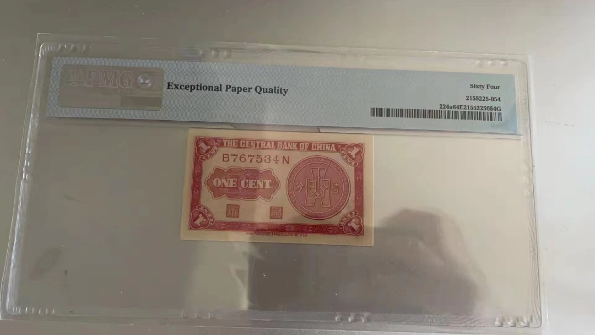 【华誉王者】2010期拍卖 民国纸币中央银行一分pmg，烈士塔一分民国28年中央银行一分纸币，前后字轨，非常袖珍的红一分。颜值，数量都稀少，居中不好，64e移位趣味币一对。B767535N