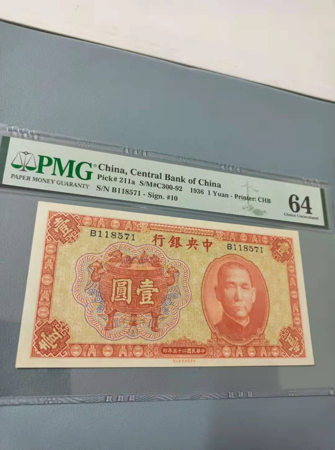 【华誉王者】2027期拍卖 1936年一元中央银行民国二十五年PMG64分，B118571稀少品种俗称宝鼎，背面马拉车孙中山水印，中华书局如图发货！