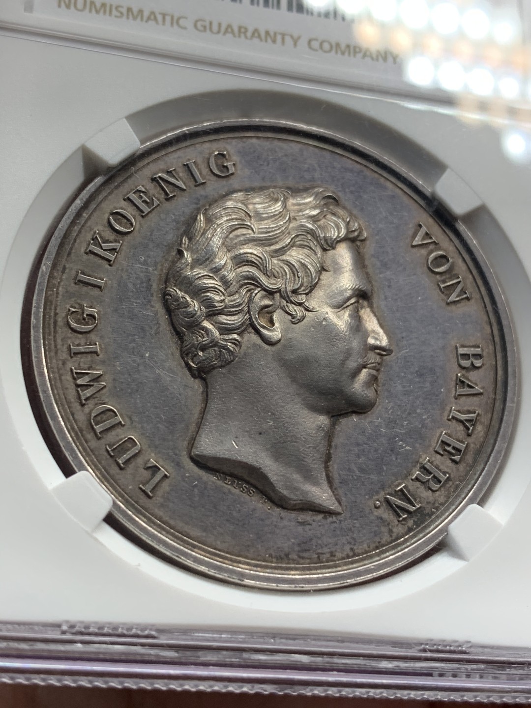 《竞宝斋》中天佳节（端午节特拍）6月12日-周日-第64场 NGC MS62 德国1838年 巴伐利亚路德维希一世奥格斯堡练兵营纪念景观大银章，AW去年61分的3600多成交，这个62分。背面中央是一块钴，钴是当时的稀有金属