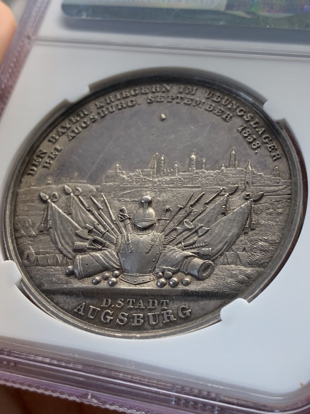 《竞宝斋》中天佳节（端午节特拍）6月12日-周日-第64场 NGC MS62 德国1838年 巴伐利亚路德维希一世奥格斯堡练兵营纪念景观大银章，AW去年61分的3600多成交，这个62分。背面中央是一块钴，钴是当时的稀有金属