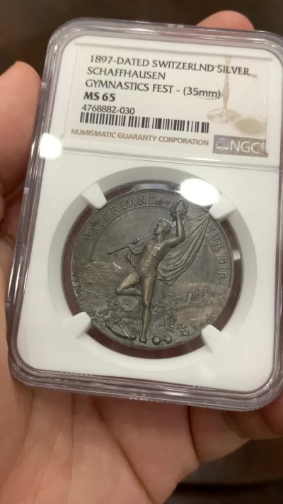 《竞宝斋》中天佳节（端午节特拍）6月12日-周日-第64场 NGC MS65 瑞士1897年沙夫豪森体操节银章 镜面加磨砂工艺 在当时无法想象  正面凹形 底板 更显高浮雕技艺 人物衣服的褶皱清晰 景观精制 难得！