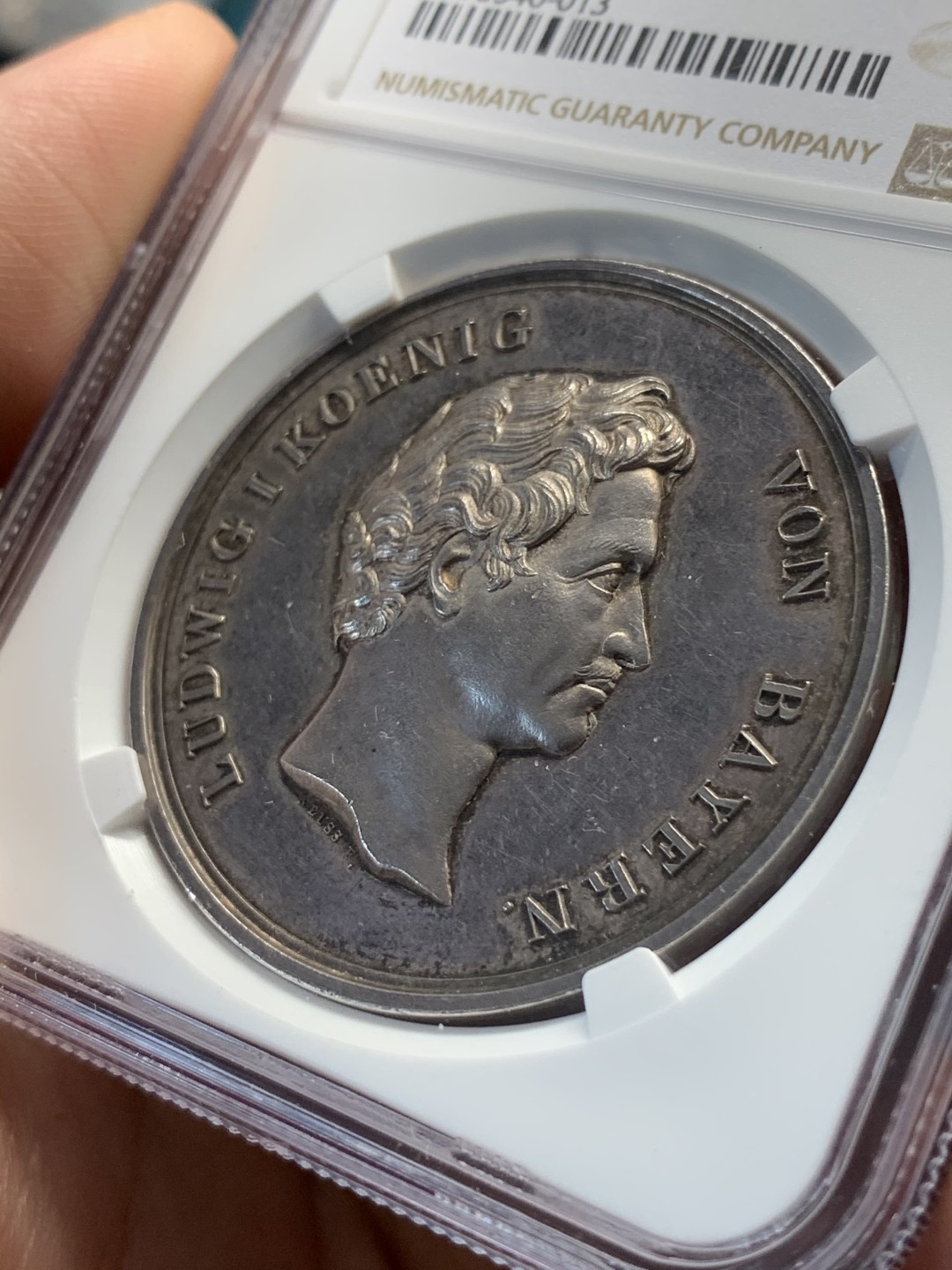 《竞宝斋》中天佳节（端午节特拍）6月12日-周日-第64场 NGC MS62 德国1838年 巴伐利亚路德维希一世奥格斯堡练兵营纪念景观大银章，AW去年61分的3600多成交，这个62分。背面中央是一块钴，钴是当时的稀有金属