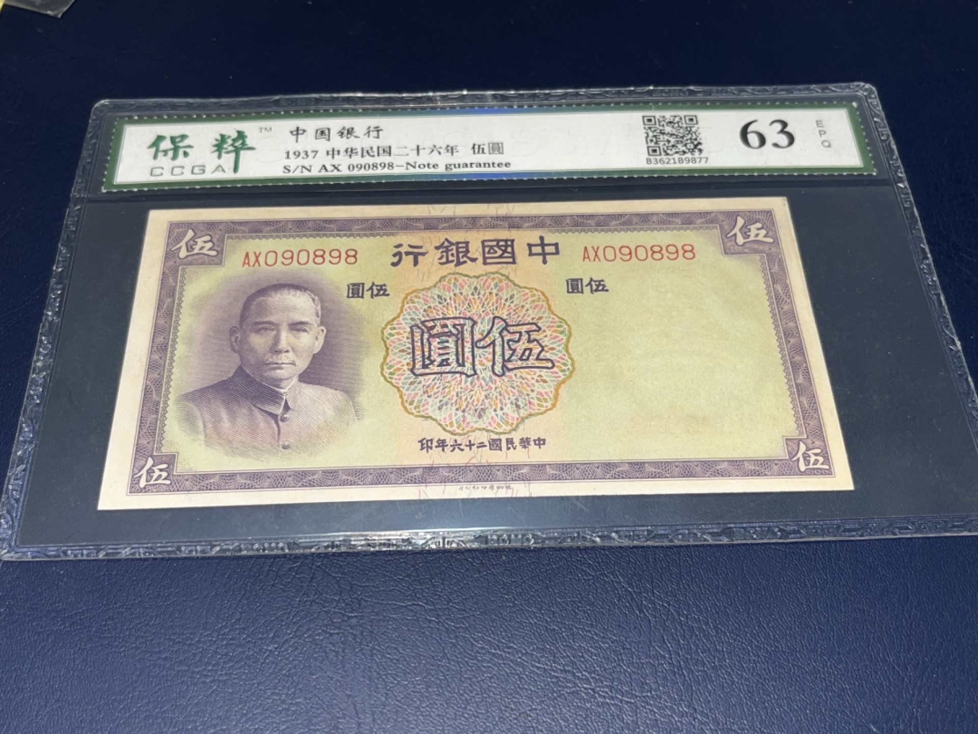 【华誉王者】2041期拍卖 （民国）二十六年，中央银行、米黄、伍元、全新、原票、保粹评级！63E分、非常漂亮，天坛水印、全程无、4、7，数三、又是倒置号、尾8、AX090898、号码清清爽爽、快百年的藏品、这种品相的现已经不多了、值得投资收藏！