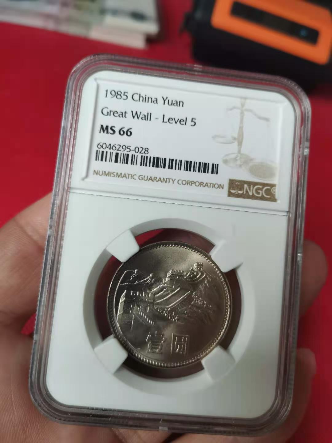 【华誉王者】2046期拍卖 85年长城壹圆窄版彩红版一身，卷拆品相。NGC66分，串号028。