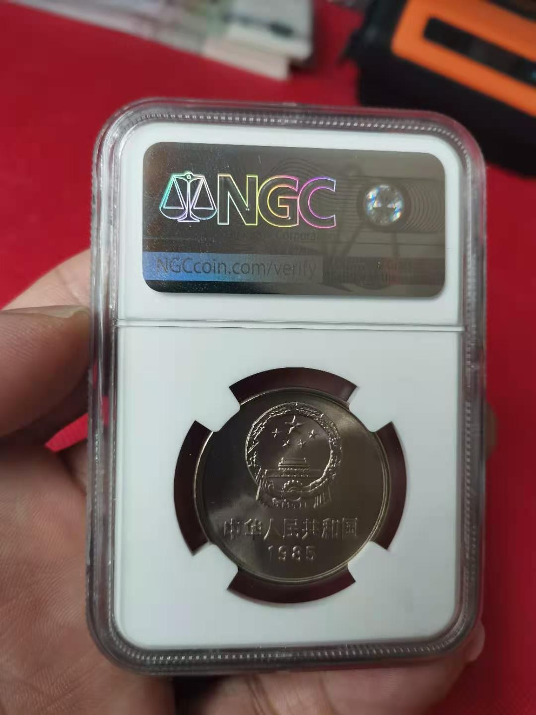 【华誉王者】2046期拍卖 85年长城壹圆窄版彩红版一身，卷拆品相。NGC66分，串号028。