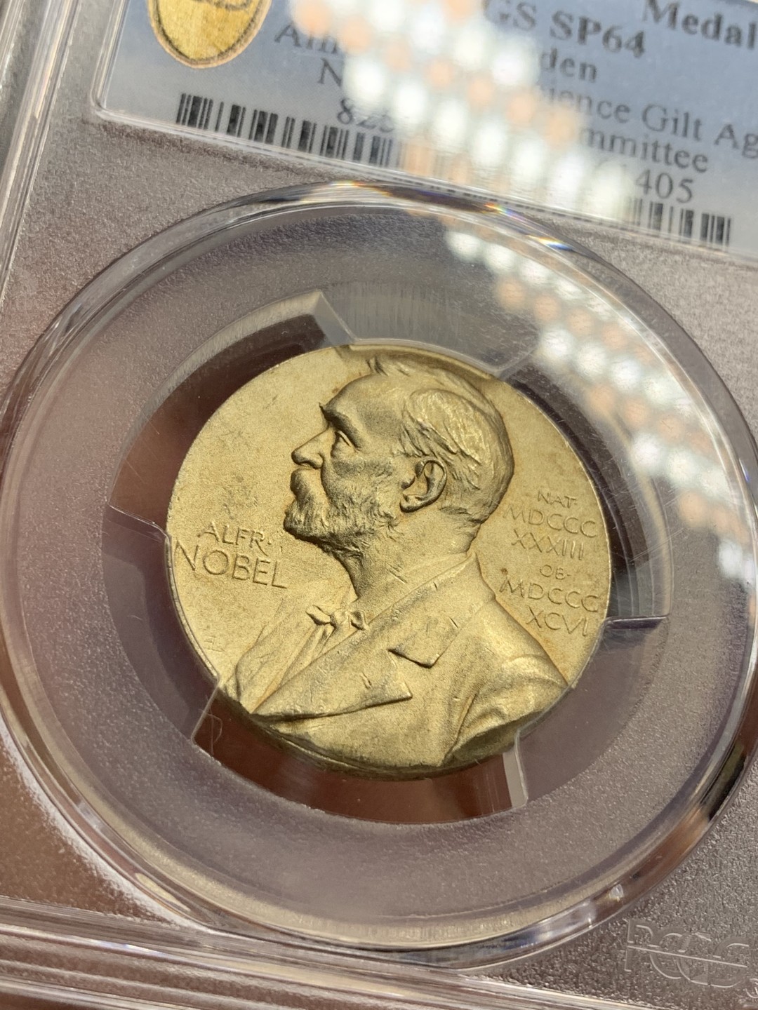 《竞宝斋》第76场-本周日，周一2场连拍（全场不限金额包邮） PCGS SP64 1996-2000年间瑞典诺贝尔物理学和化学奖评审委员会镀金银章，盒子背面左下有磕