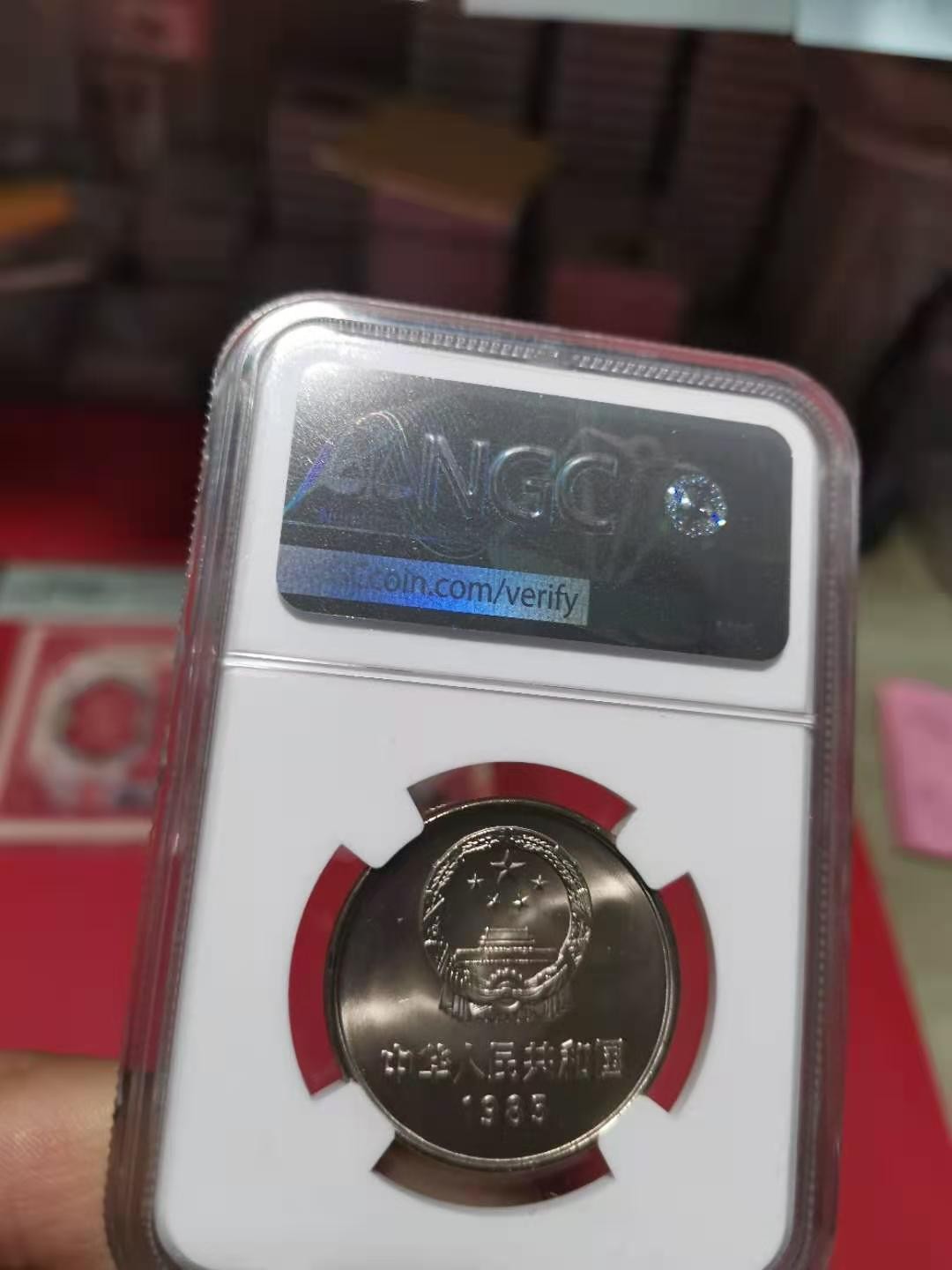 【华誉王者】2072期拍卖 85年长城壹圆窄版彩红版一身，卷拆品相。NGC66分，串号029。