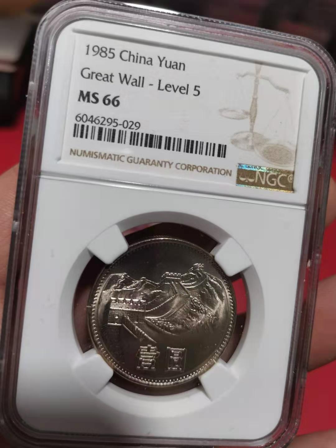【华誉王者】2072期拍卖 85年长城壹圆窄版彩红版一身，卷拆品相。NGC66分，串号029。