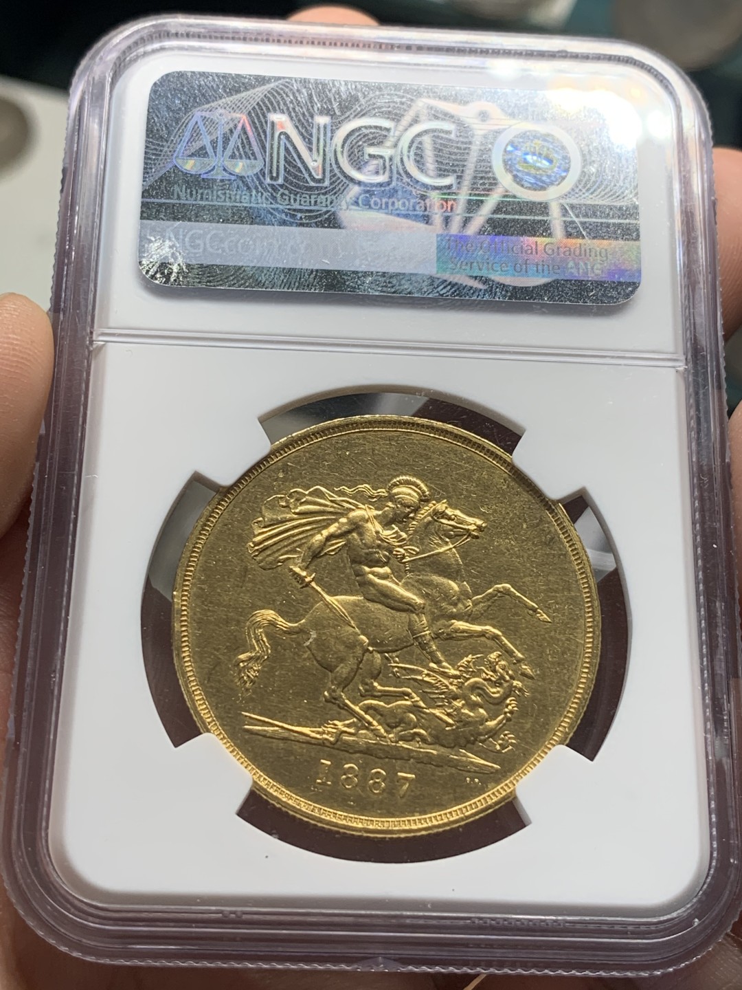 《竞宝斋》第83场-本周日，周一2场连拍（全场不限金额包邮） NGC UNC 原光英国1887年维多利亚高冠马剑5索维林金币，40克大金币，细节完好，整体状态佳，人像非常漂亮