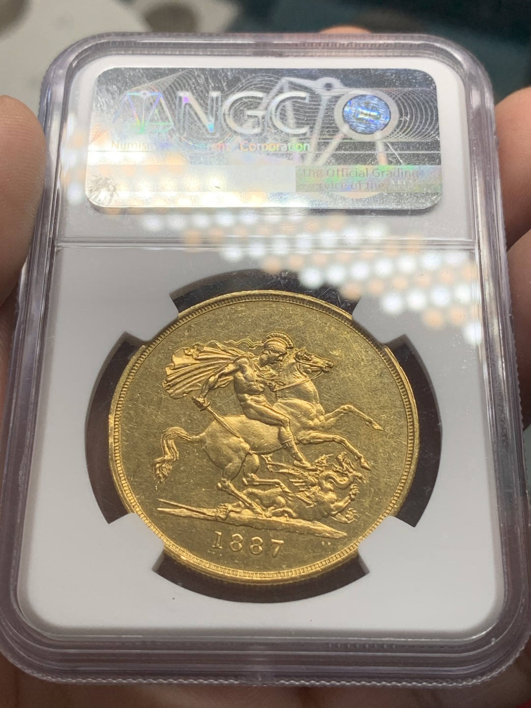 《竞宝斋》第83场-本周日，周一2场连拍（全场不限金额包邮） NGC UNC 原光英国1887年维多利亚高冠马剑5索维林金币，40克大金币，细节完好，整体状态佳，人像非常漂亮