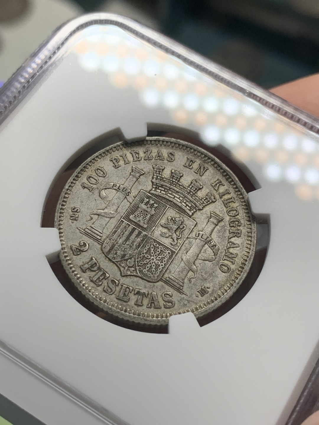 《竞宝斋》第85场-本周日，周一2场连拍（全场不限金额包邮） 第三名 NGC-AU50 西班牙1870年 星星70， 坐花双柱2比塞塔银币 此版配背字“SNM”是最少见的 更高分也就2枚