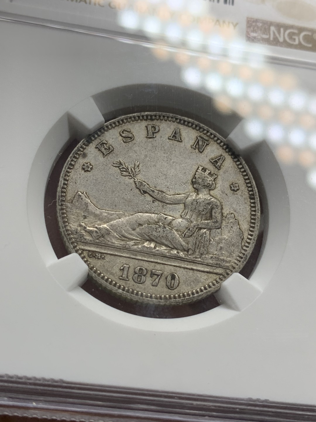 《竞宝斋》第85场-本周日，周一2场连拍（全场不限金额包邮） 第三名 NGC-AU50 西班牙1870年 星星70， 坐花双柱2比塞塔银币 此版配背字“SNM”是最少见的 更高分也就2枚