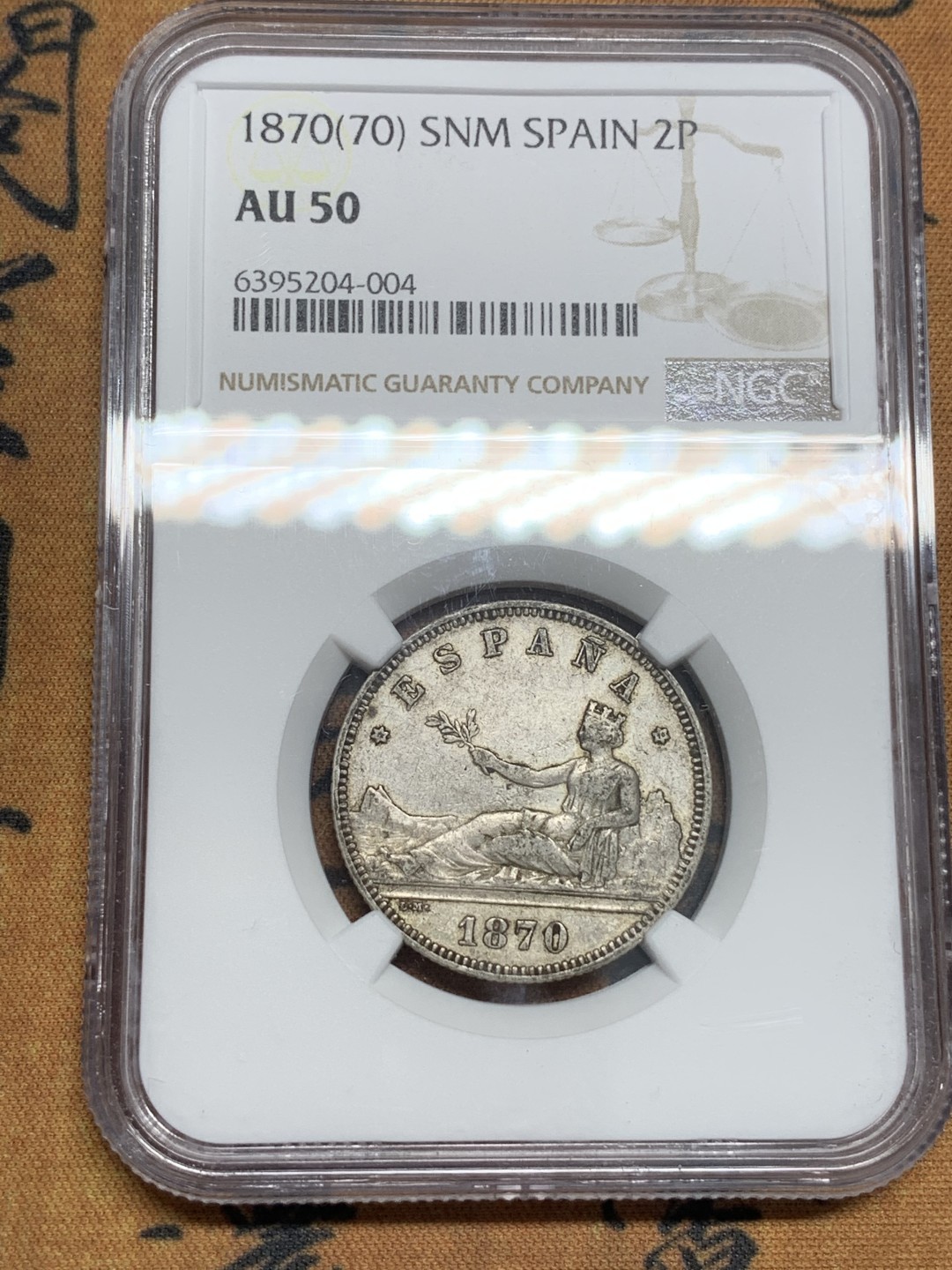 《竞宝斋》第85场-本周日，周一2场连拍（全场不限金额包邮） 第三名 NGC-AU50 西班牙1870年 星星70， 坐花双柱2比塞塔银币 此版配背字“SNM”是最少见的 更高分也就2枚