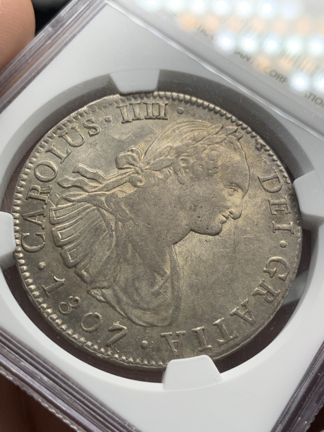 《竞宝斋》第85场-本周日，周一2场连拍（全场不限金额包邮） NGC AU58 1807年墨西哥双柱8R银币 自然包浆 底光透现 背面感光极佳 正面人像左侧有透打 打制深极难得