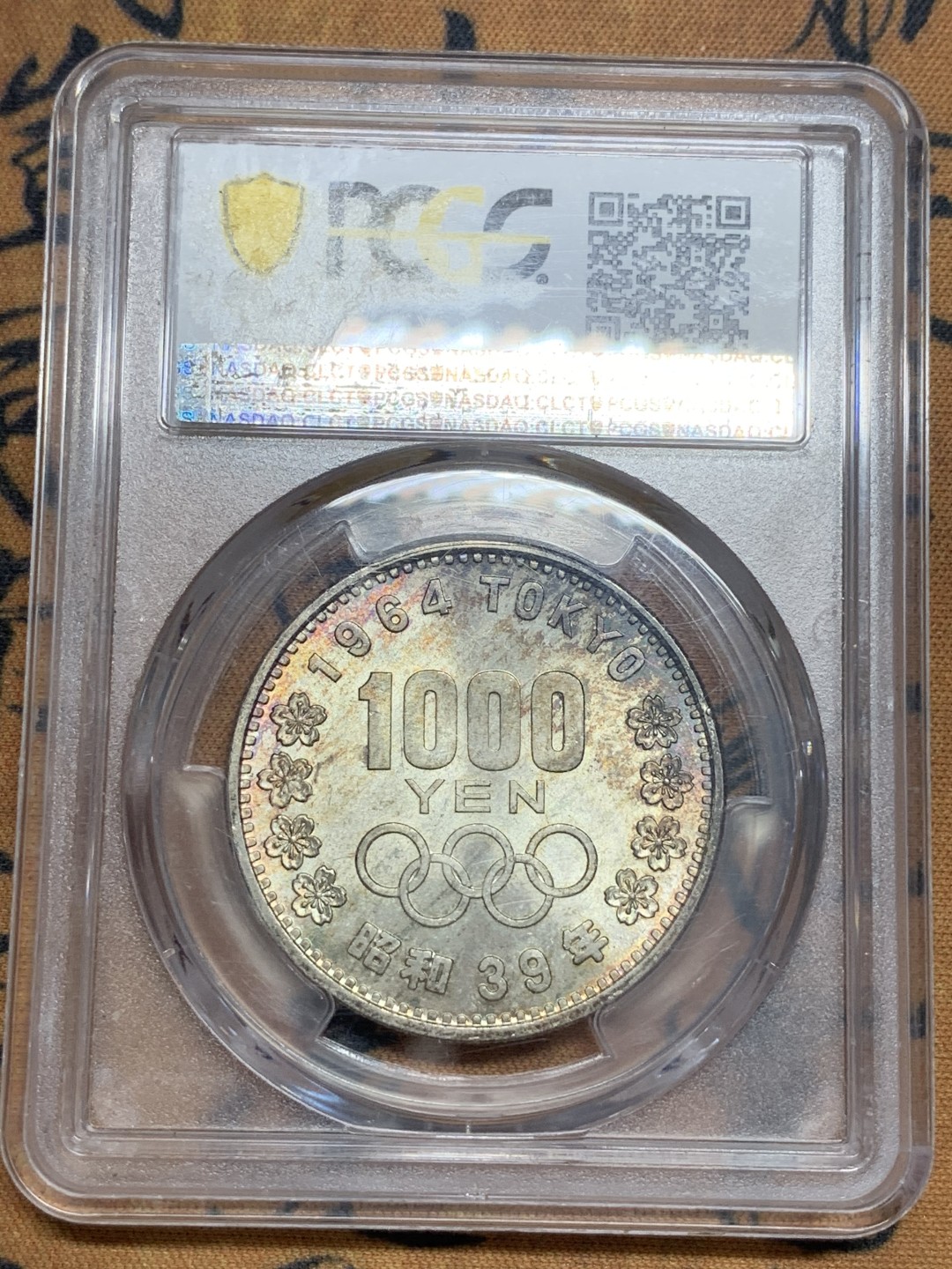 《竞宝斋》第85场-本周日，周一2场连拍（全场不限金额包邮） PCGS MS65 日本 1964年 1000日元 日本东京奥运会银币 紫彩有很均匀的拉丝排列，视觉效果一流可对比官网图