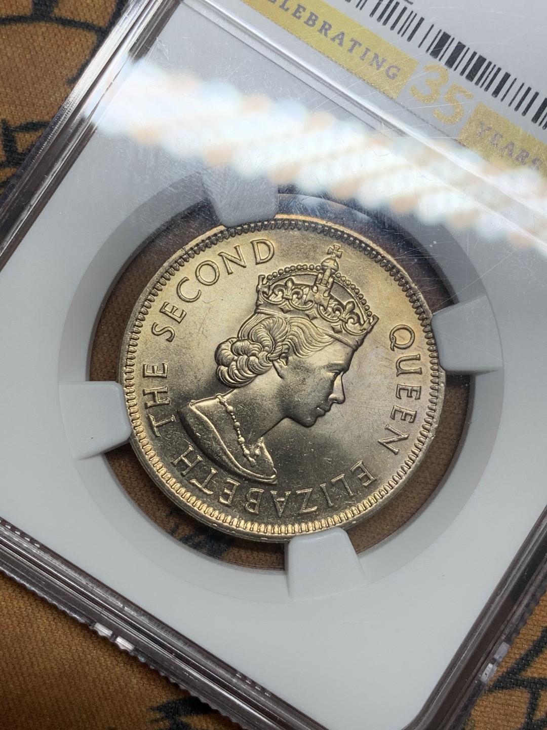 《竞宝斋》第93场-本周日，周一2场连拍（全场不限金额包邮） NGC MS64 35周年标香港大一元1975年 黄油曝光，十分精美。